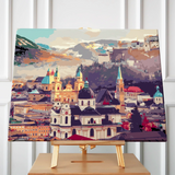 European cityscape painting with historic architecture and mountain backdrop