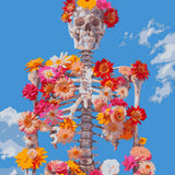 Skeleton adorned with colorful flowers against a bright blue sky