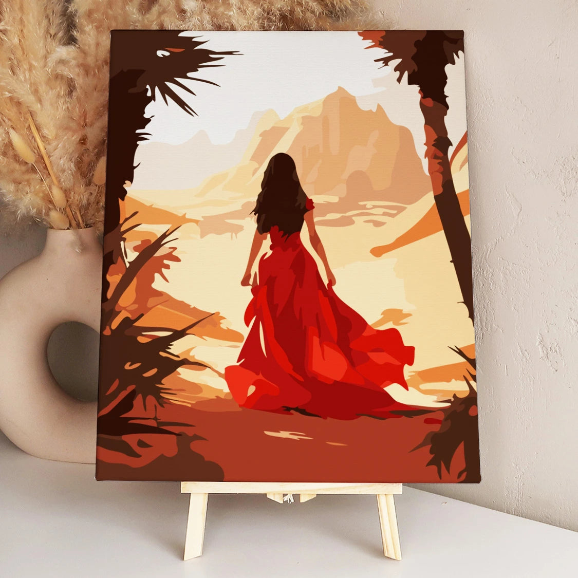 Woman in flowing red dress walking through a desert landscape