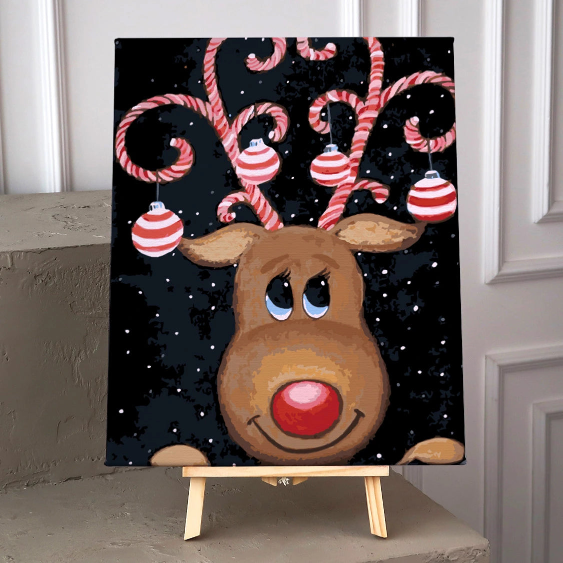 Painting of a reindeer with candy cane antlers and ornaments