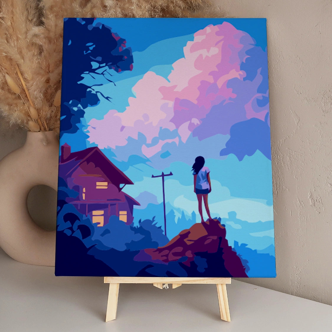 Silhouetted girl gazing at vibrant pink and blue sunset clouds
