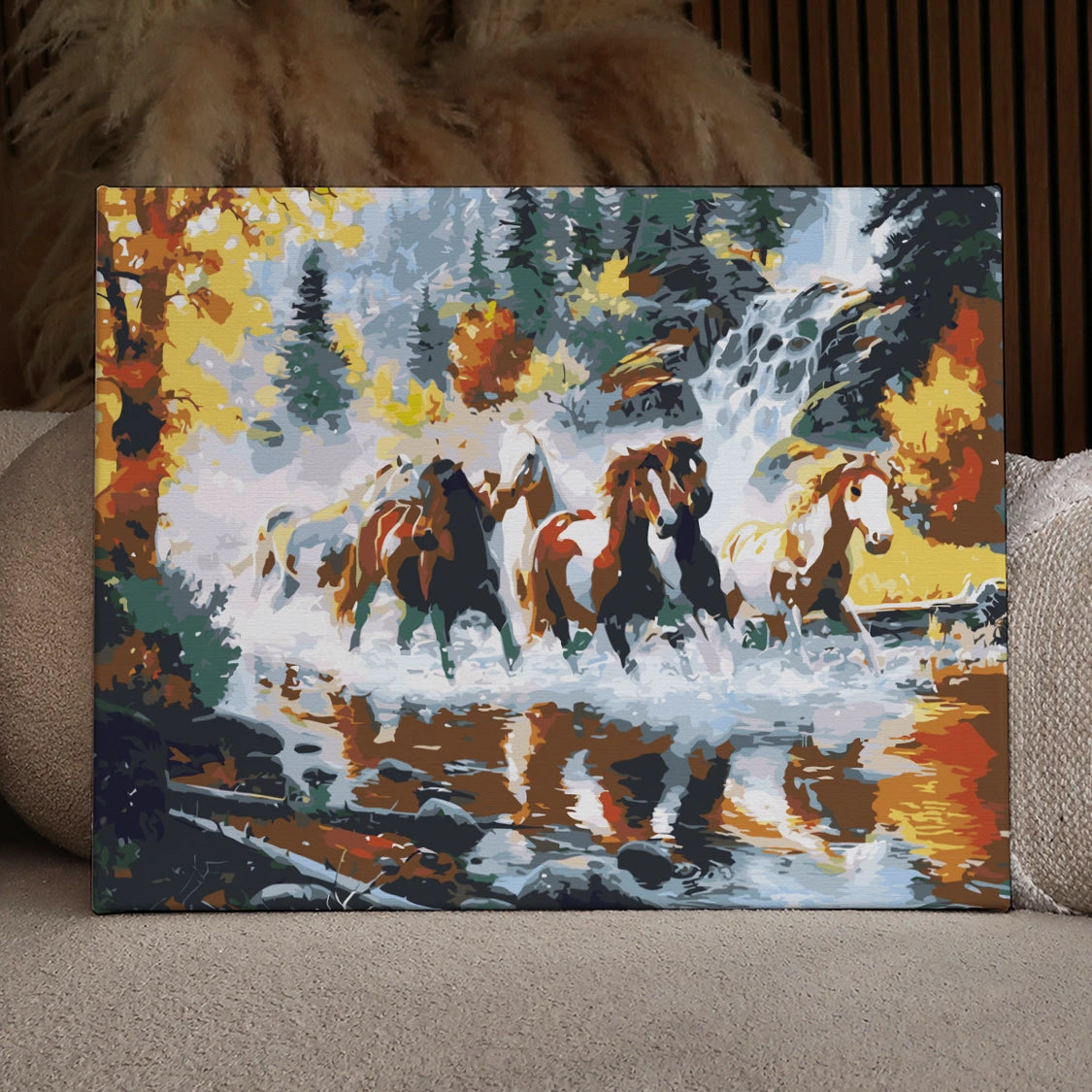 Wild horses galloping through a river with waterfall and autumn trees