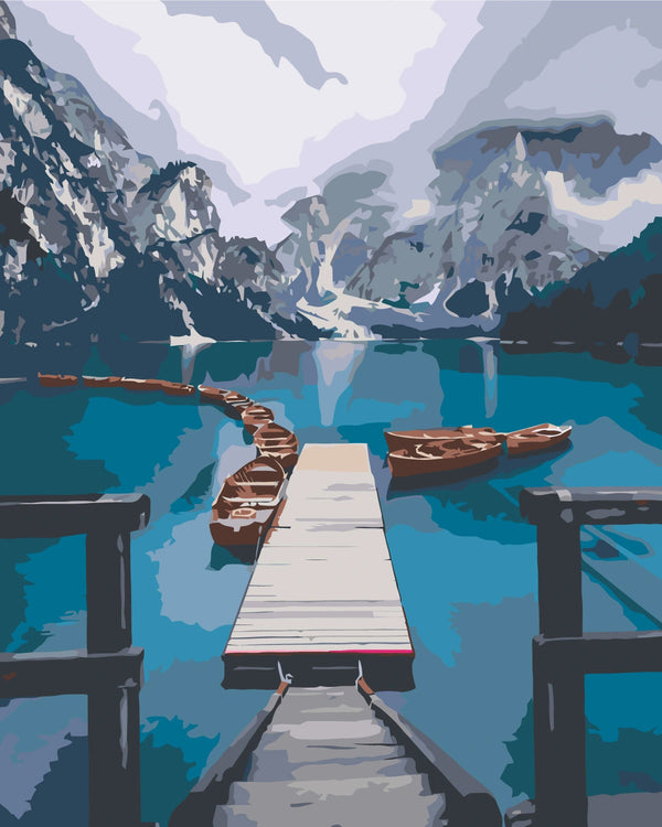 Scenic mountain lake with wooden dock and boats in calm water