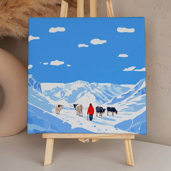 Shepherd guiding cows through snowy mountain landscape under blue sky