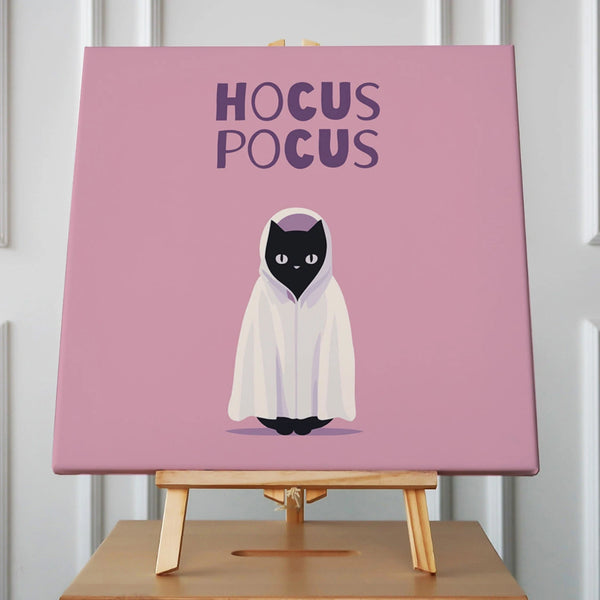 Black cat in ghost costume with "Hocus Pocus" text on pink background