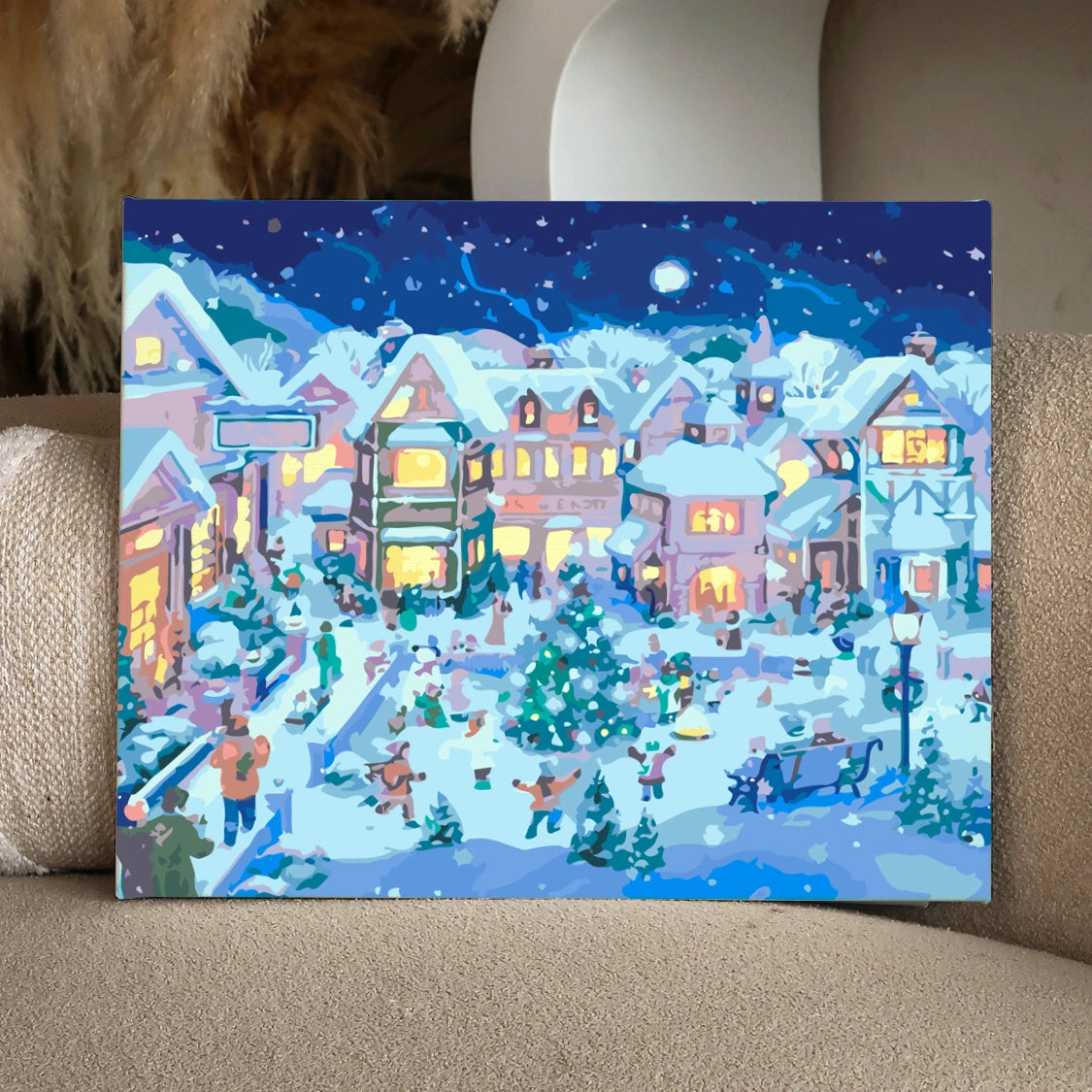 Painting of a festive snowy village with people celebrating Christmas