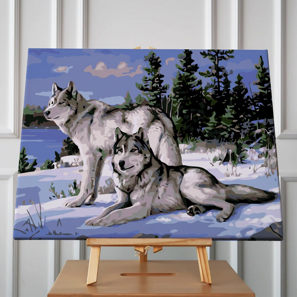 Two wolves in a snowy forest with a lake background
