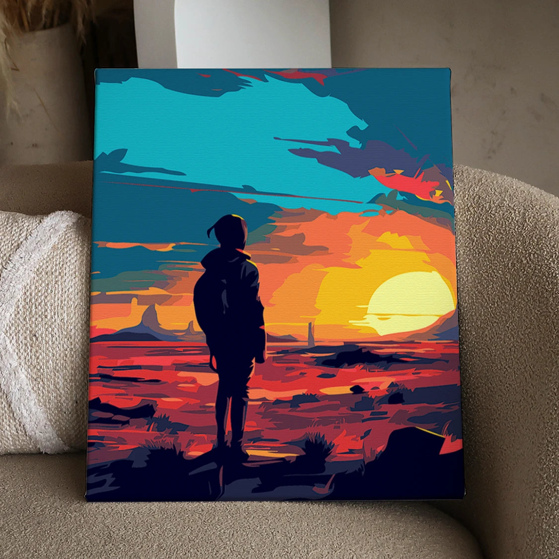 Silhouetted figure watching vibrant sunset over desert landscape painting