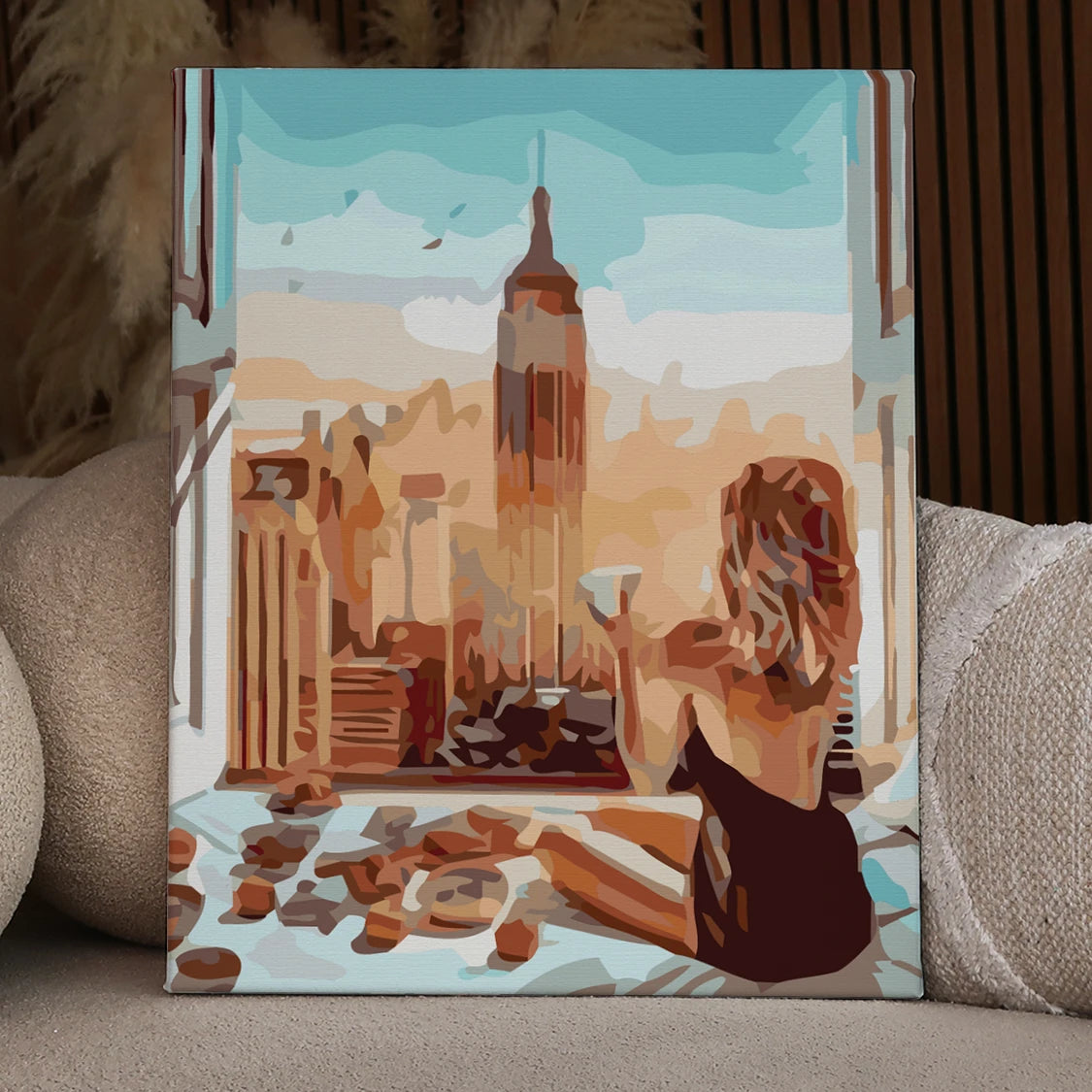 Woman enjoying coffee in bed with Empire State Building view