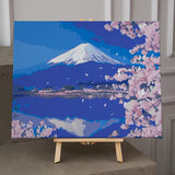 Snow-capped Mount Fuji with cherry blossoms and serene lake reflection