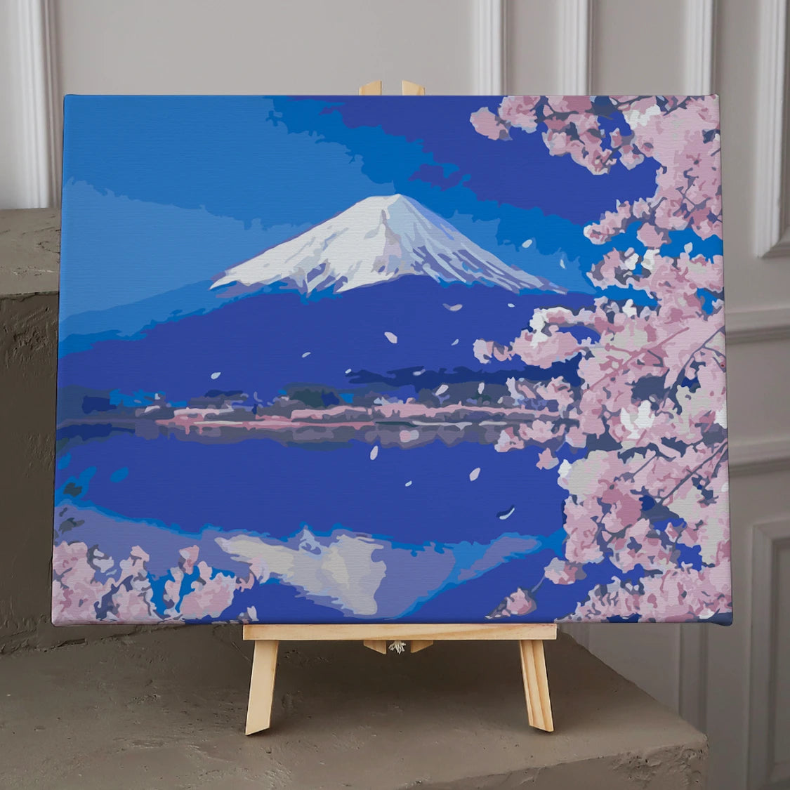 Snow-capped Mount Fuji with cherry blossoms and serene lake reflection