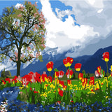 Vibrant tulip field with a tree and mountain backdrop