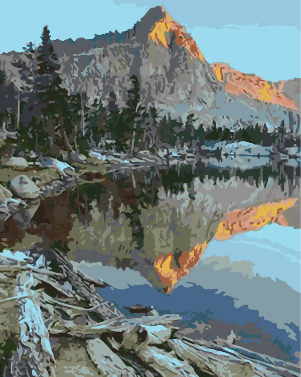 Mountain landscape reflecting in a calm lake at sunrise