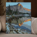 Mountain landscape reflecting in a calm lake at sunrise