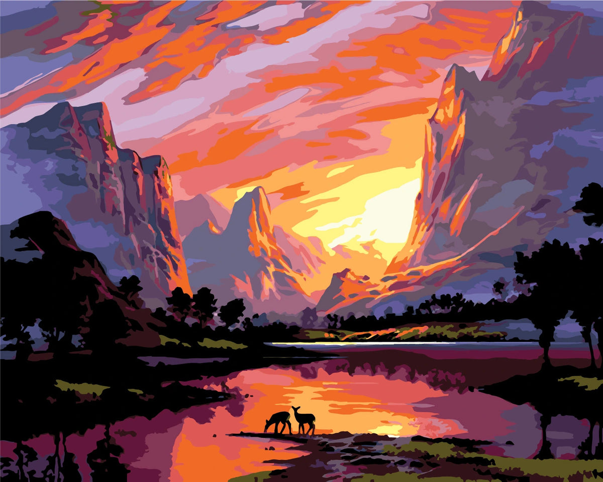 Majestic sunset over mountains with deer by a reflective lake