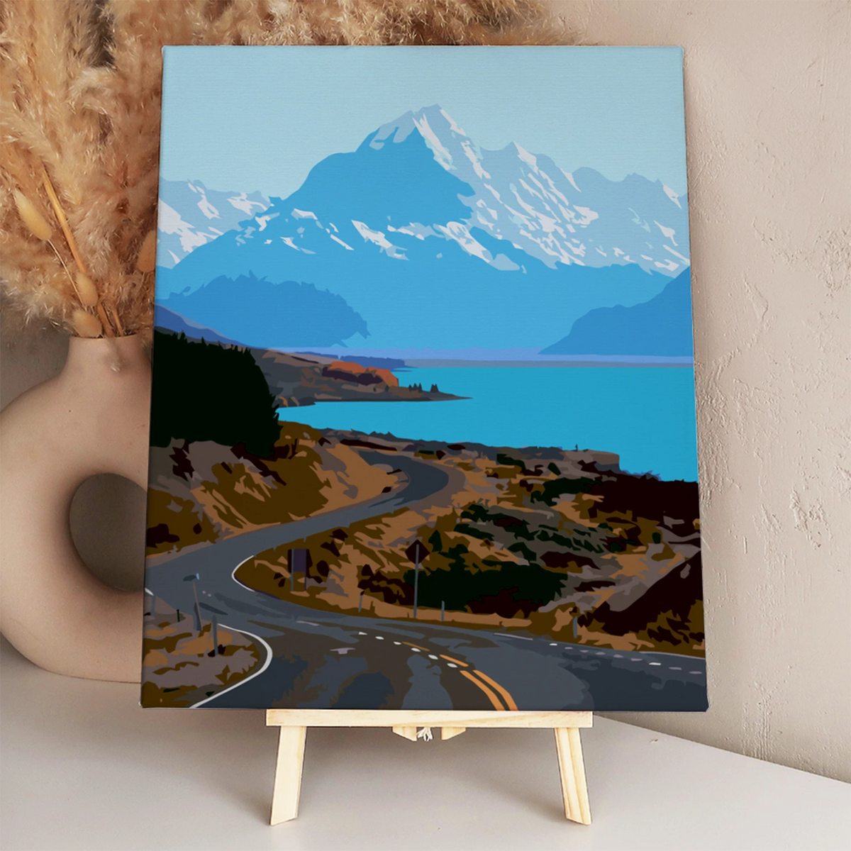 Winding road leading to blue lake and snow-capped mountains painting