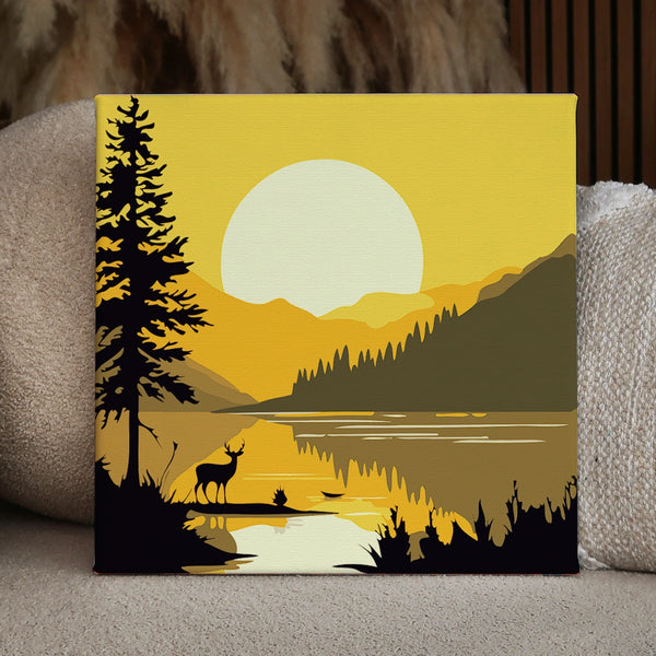 Silhouette of a deer by a lake with sunset mountains