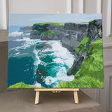 Cliffs overlooking the ocean with crashing waves and green hills painting