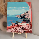 Scenic coastal terrace with chairs overlooking a Mediterranean village