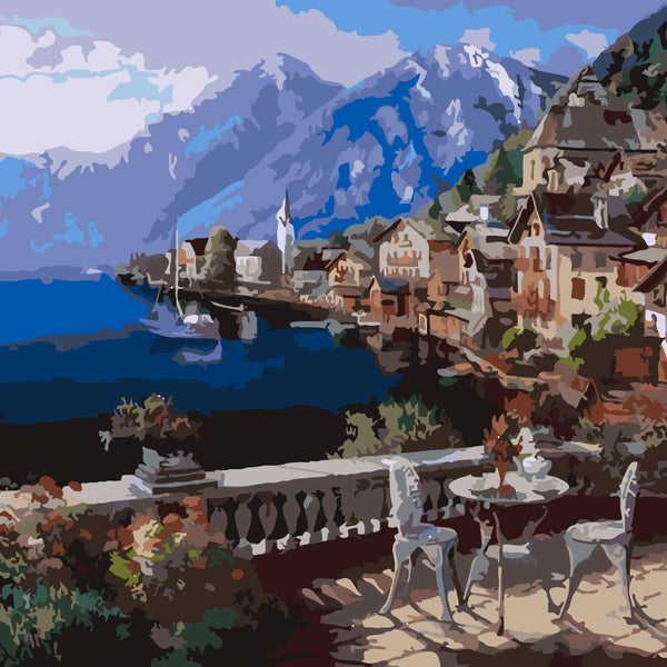 Scenic lakeside village with mountains and outdoor café setting.