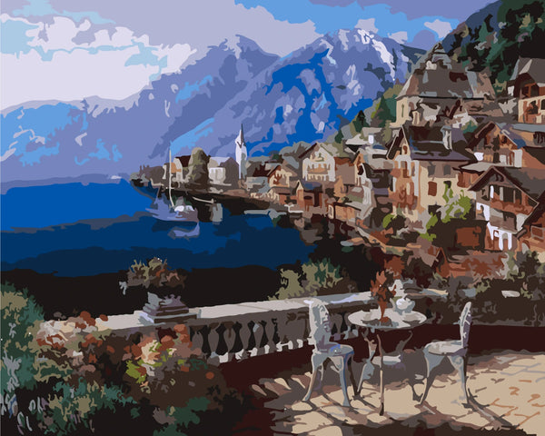 Scenic lakeside village with mountains and outdoor café setting.