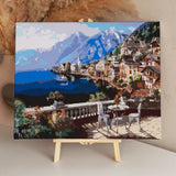 Scenic lakeside village with mountains and outdoor café setting.