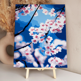 Stylized painting of cherry blossoms against a bright blue sky
