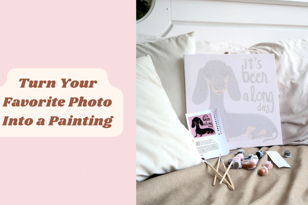 Paint by numbers canvas with dachshund illustration, acrylic paints, and brushes displayed on a sofa for a relaxing art hobby