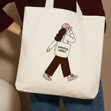 Beige tote bag with a girl illustration and the text Painting Addict