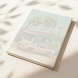 Framed paint by numbers canvas depicting a retro palm-lined street with a pastel house and classic pink car