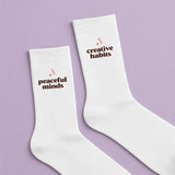 White socks with the text Peaceful Minds and Creative Habits