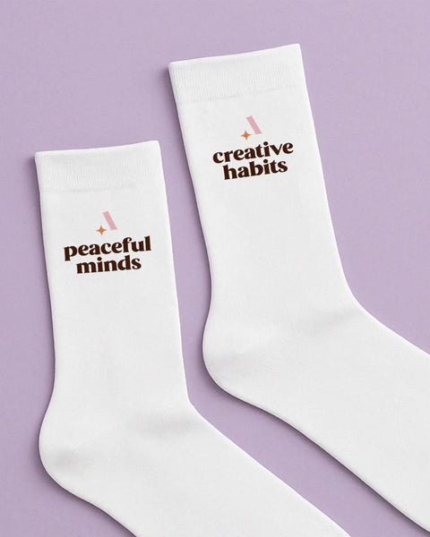 White socks with the text Peaceful Minds and Creative Habits