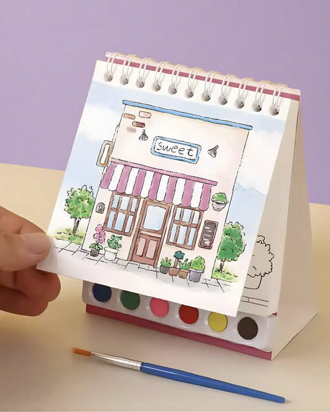 Compact travel art kit with watercolor paints, brush, and spiral pad