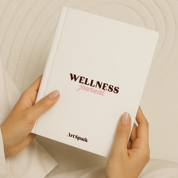 White wellness journal held in hands with pink and brown lettering