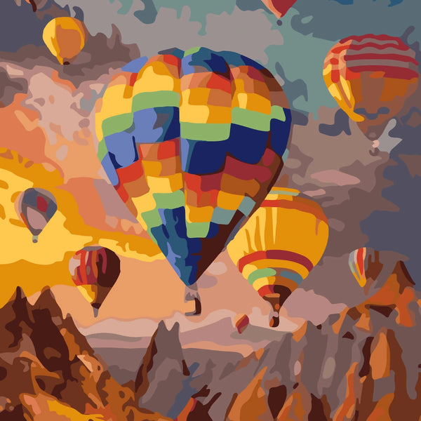 Colorful hot air balloons floating over a mountainous landscape at sunset