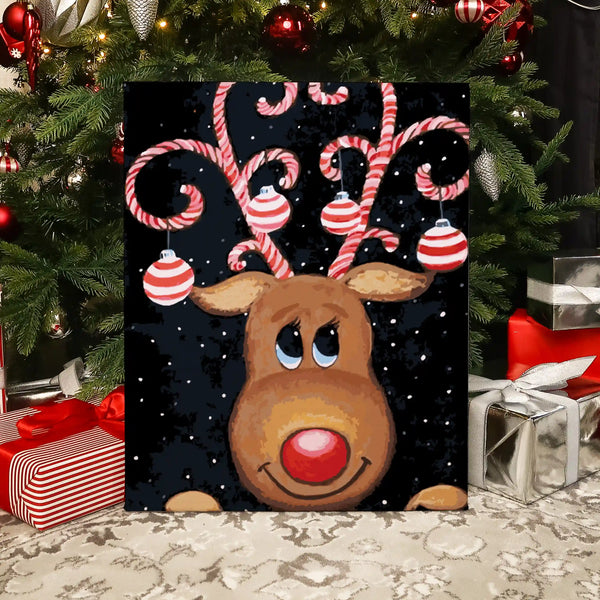 Completed Christmas Dear paint by numbers artwork showing a reindeer with candy cane antlers and ornaments on a snowy background.