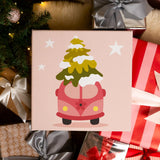 Completed Christmas Van paint by numbers artwork showing a pink van with a Christmas tree, surrounded by holiday gifts and lights.
