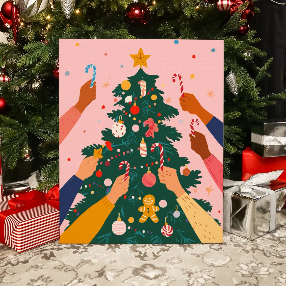 Completed Festive Tree paint by numbers artwork showing hands decorating a Christmas tree with candy canes and ornaments.