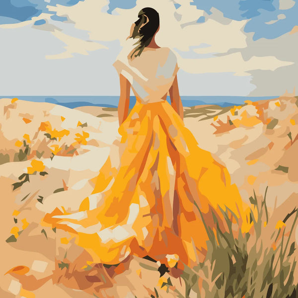 Woman in flowing yellow dress standing on a sandy beach