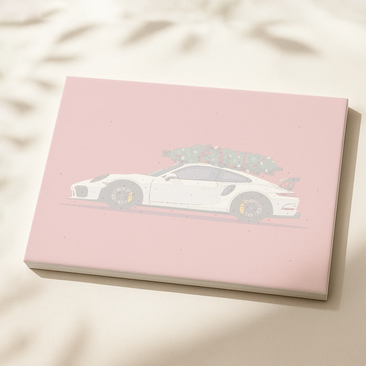 Holiday Ride paint by numbers canvas featuring a white sports car carrying a Christmas tree on its roof.
