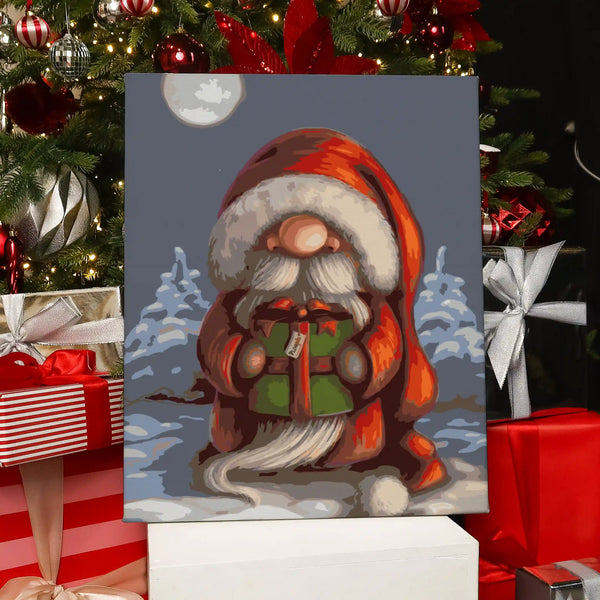 Completed Little Santa paint by numbers artwork showing Santa with a red coat holding a green present in the snow.