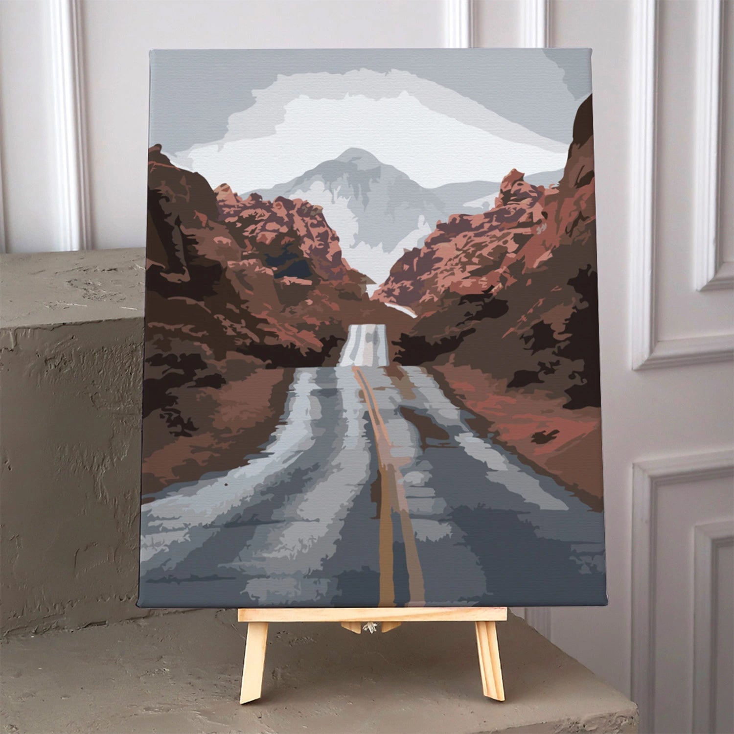 Desert highway leading to mountains with cloudy sky painting