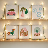 Completed Whimsical Holiday paint by numbers canvases by Artspark showing pastel festive scenes like a dachshund on skis, snow globe, and gingerbread house — modern cozy wall art.