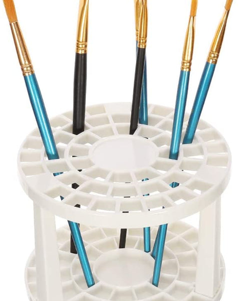 White paint brush holder stand with multiple brushes – ideal for drying and organizing art tools in a creative workspace